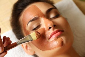 woman while facial cosmetic procedure in spa salon