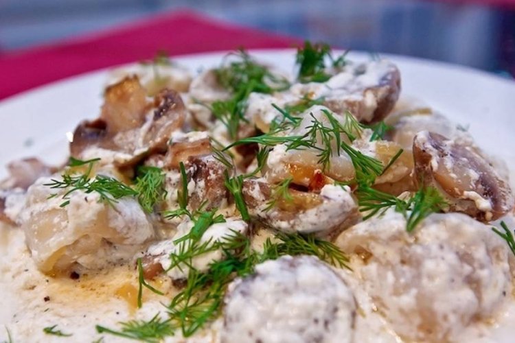 Fried dumplings with mushrooms in sour cream