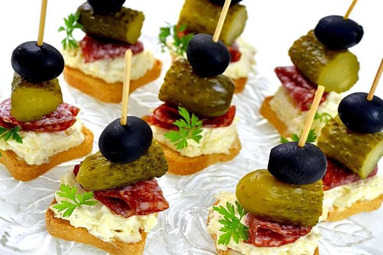 Canapes with sausage, pickles and olives