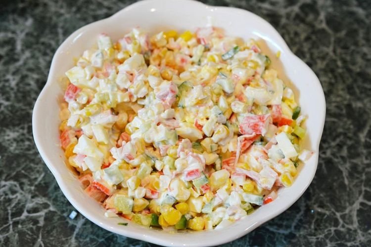 Salad with crab sticks, cucumbers, corn and pigtail cheese