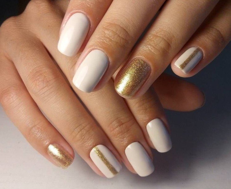 Manicure with golden sparkles on a white background